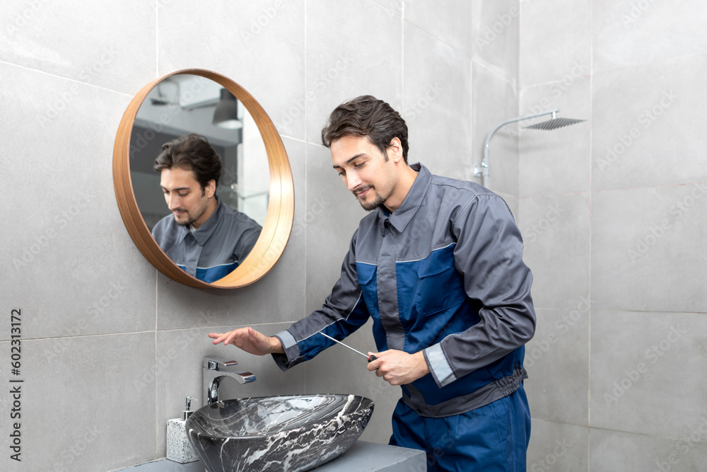 Close up photo of plumber with screwdriver fixing faucet in the bathroom. Handyman repairs a water tap Close up photo of plumber with screwdriver fixing faucet in the bathroom. Handyman repairs a water tap