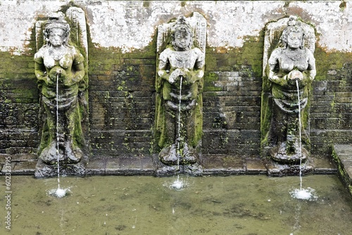 Ancient water dispensing statues at the Goa Gajah temple in Ubud, Bali, Indonesia. Elephant cave in Balinese temple. Bali temple with famous elephant cave. Indonesian famous tourist site. 