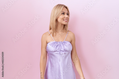 Young caucasian woman wearing lingerie dress looking away to side with smile on face, natural expression. laughing confident.