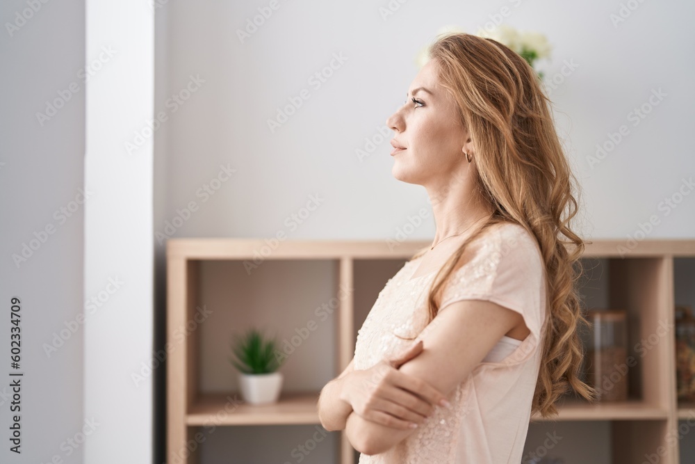 Young blonde woman standing with arms crossed gesture and serious expression at home Young blonde woman standing with arms crossed gesture and serious expression at home