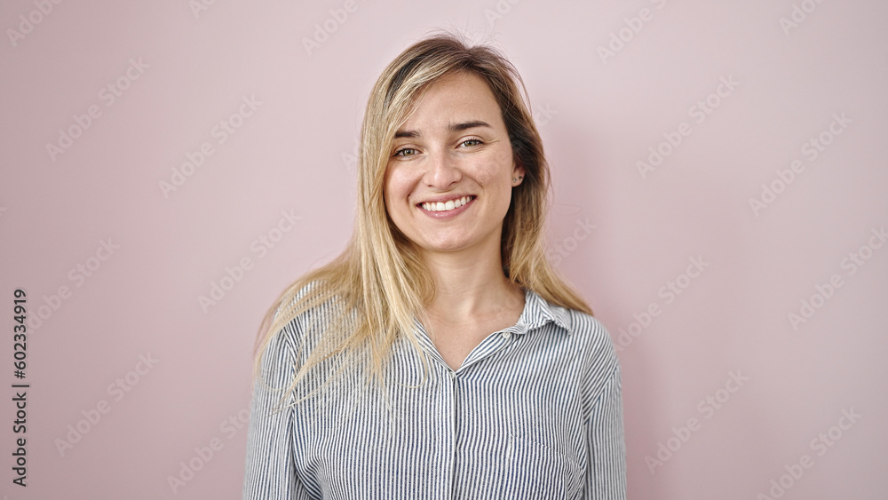 Obraz premium Young blonde woman smiling confident standing over isolated pink background
