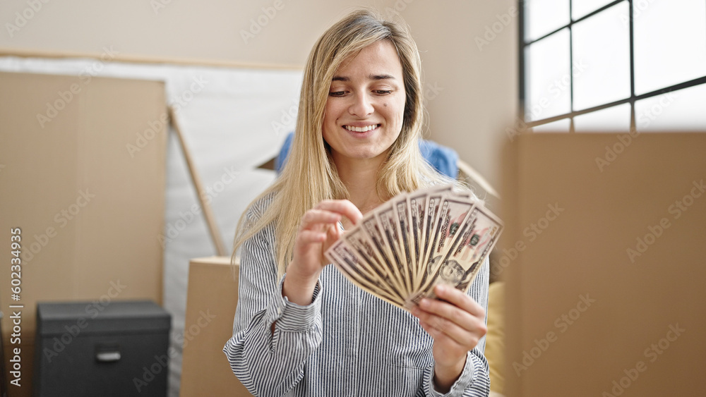 Young blonde woman smiling confident holding dollars at new home Young blonde woman smiling confident holding dollars at new home