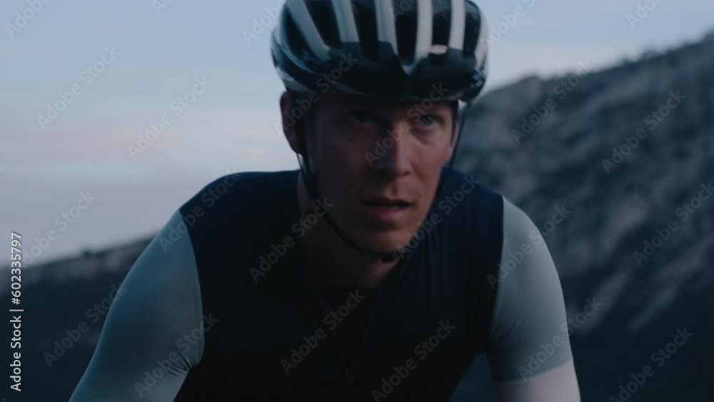 Professional athlete rides road bike on steep mountain road. Portrait of road endurance cyclist during hard training or competition race Professional athlete rides road bike on steep mountain road. Portrait of road endurance cyclist during hard training or competition race