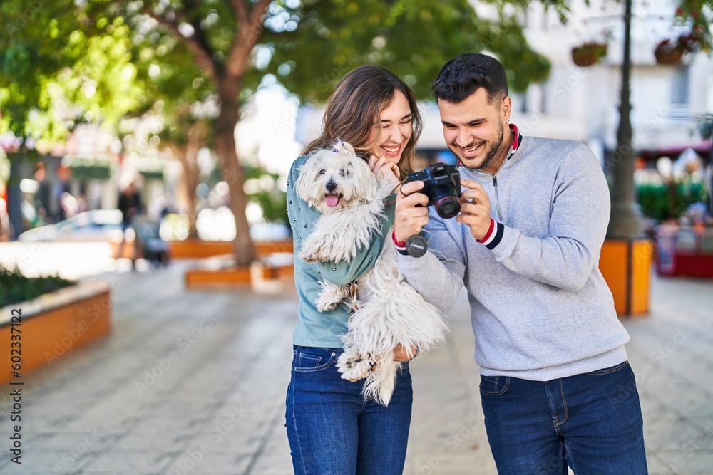 Man and woman holding dog using professional camera at park Man and woman holding dog using professional camera at park