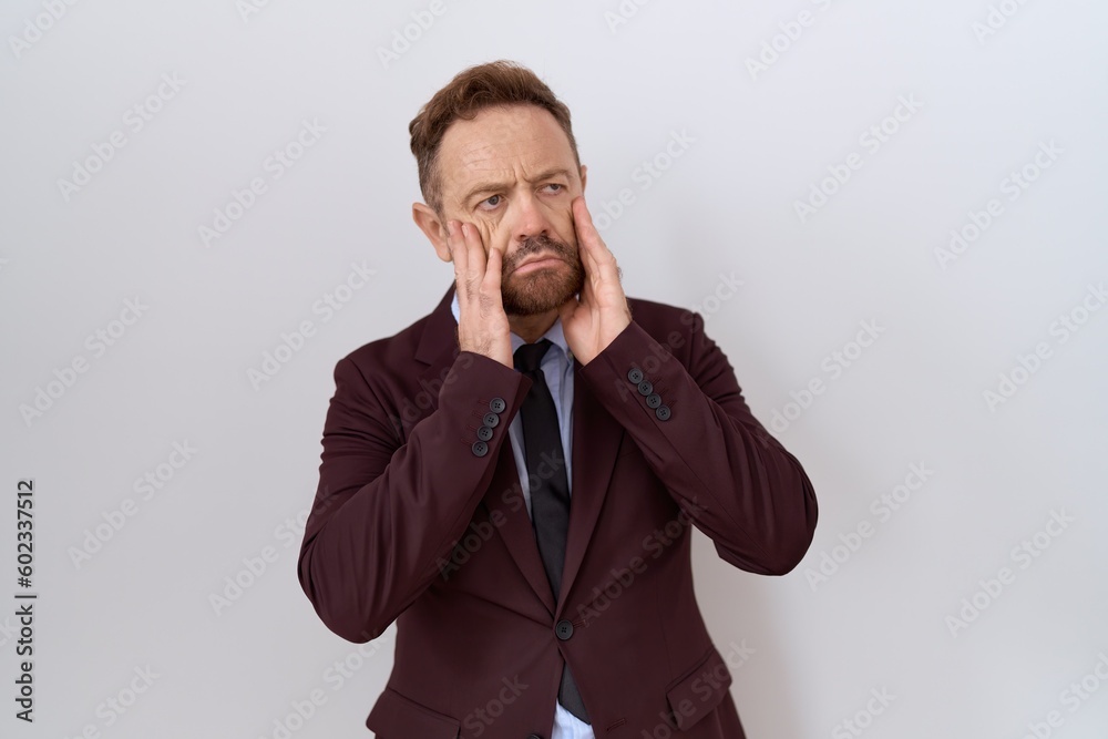 Middle age business man with beard wearing suit and tie tired hands covering face, depression and sadness, upset and irritated for problem Middle age business man with beard wearing suit and tie tired hands covering face, depression and sadness, upset and irritated for problem