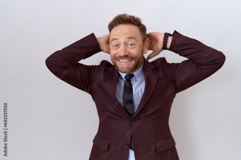 Middle age business man with beard wearing suit and tie relaxing and stretching, arms and hands behind head and neck smiling happy Middle age business man with beard wearing suit and tie relaxing and stretching, arms and hands behind head and neck smiling happy