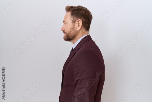 Middle age business man with beard wearing suit and tie looking to side, relax profile pose with natural face and confident smile.