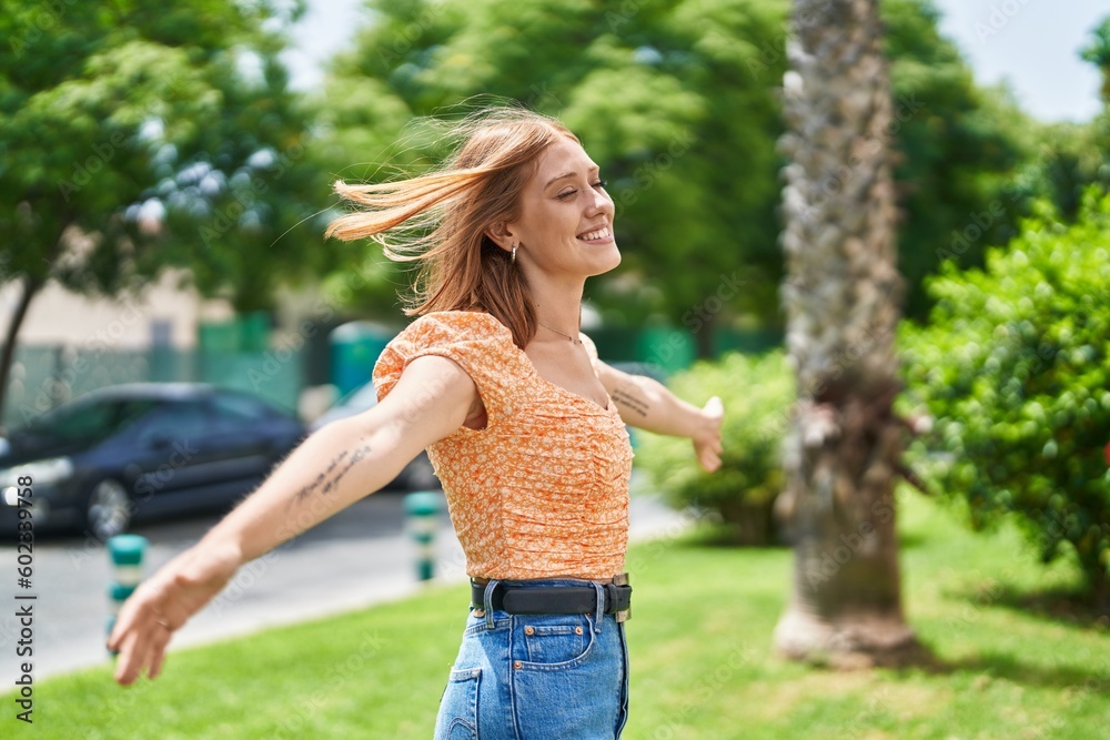 Young redhead woman smiling confident breathing at park