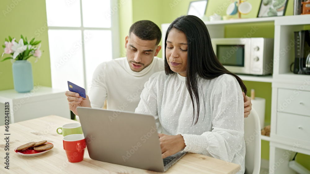 Man and woman couple having breakfast shopping with laptop and credit card at home Man and woman couple having breakfast shopping with laptop and credit card at home
