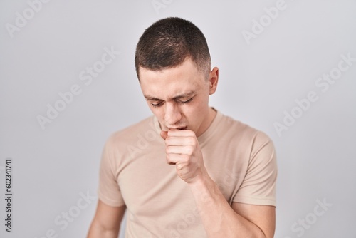 Young man standing over isolated background feeling unwell and coughing as symptom for cold or bronchitis. health care concept.