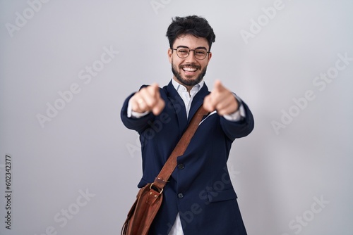 Hispanic man with beard wearing business clothes pointing to you and the camera with fingers, smiling positive and cheerful