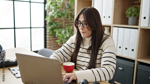 Young beautiful hispanic woman business worker using laptop at office