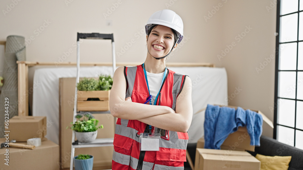 Young beautiful hispanic woman builder smiling confident standing with arms crossed gesture at new home Young beautiful hispanic woman builder smiling confident standing with arms crossed gesture at new home