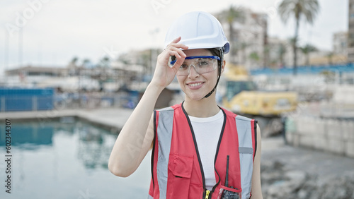 Young beautiful hispanic woman builder smiling confident standing at seaside © Krakenimages.com