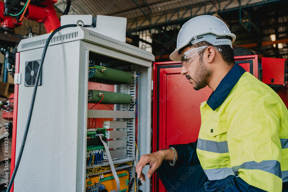 Fototapeta premium Robot machine electricity control box, Electronic technology for production factory industry, Professional technician engineer person are work with mechanical equipment tool for automation maintenance