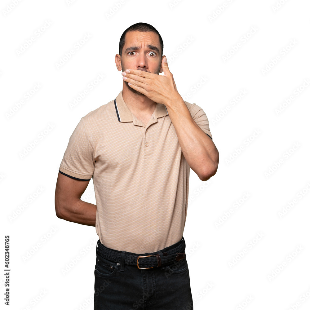 Young man covering his mouth with his hands Young man covering his mouth with his hands