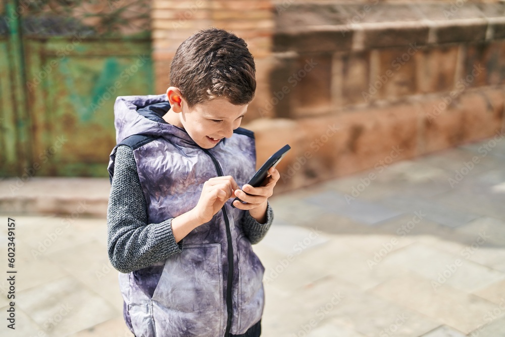 Obraz premium Blond child smiling confident using smartphone at street