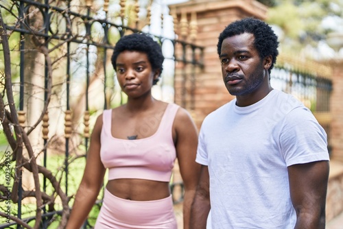 African american man and woman couple standing together with serious expression at street