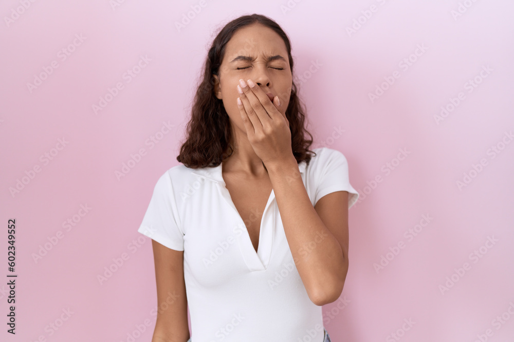 Young hispanic woman wearing casual white t shirt bored yawning tired covering mouth with hand. restless and sleepiness. Young hispanic woman wearing casual white t shirt bored yawning tired covering mouth with hand. restless and sleepiness.