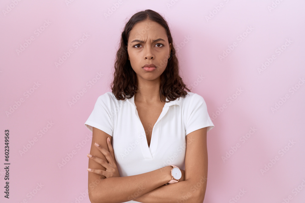 Fototapeta premium Young hispanic woman wearing casual white t shirt skeptic and nervous, disapproving expression on face with crossed arms. negative person.