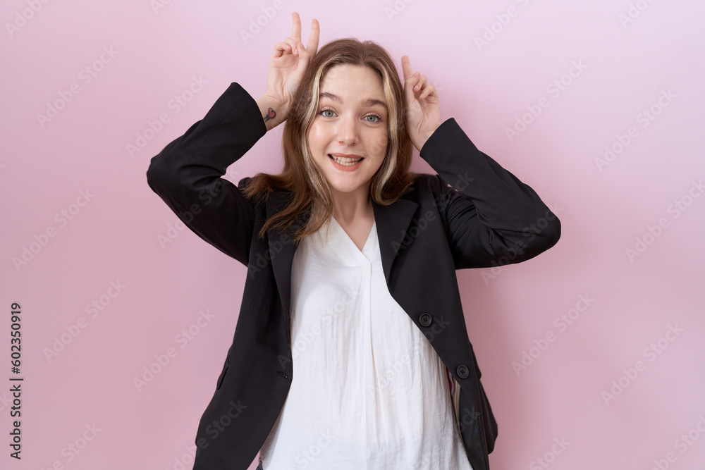 Young caucasian business woman wearing black jacket posing funny and crazy with fingers on head as bunny ears, smiling cheerful