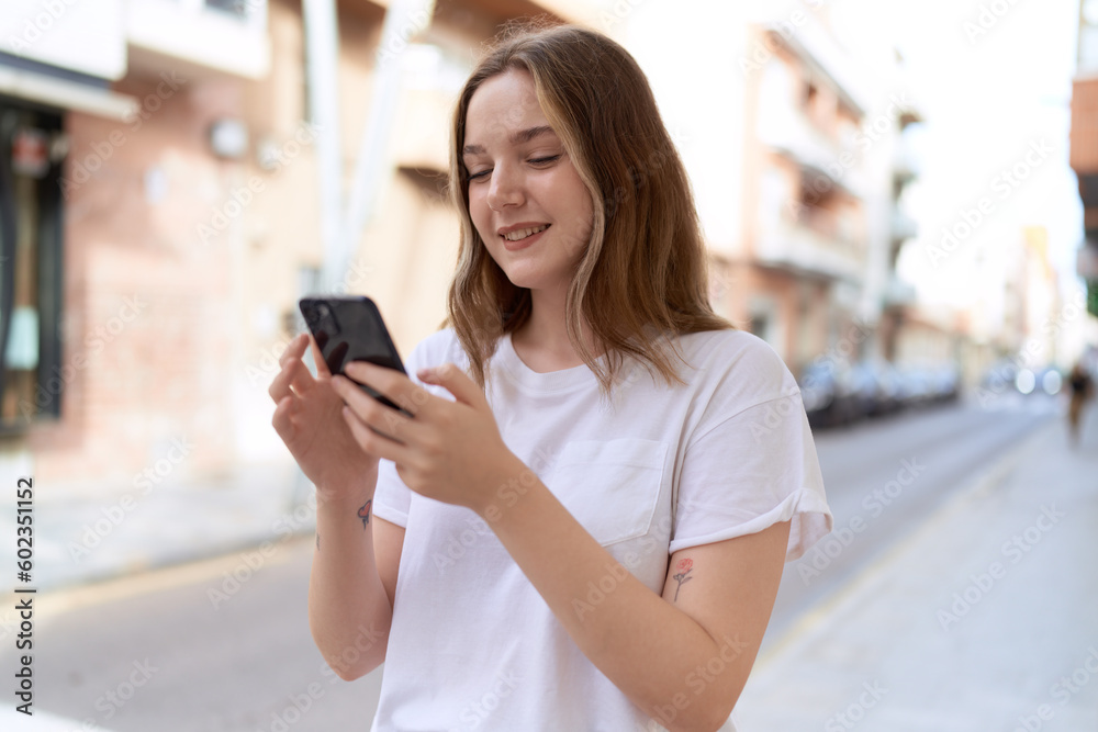 Young caucasian woman smiling confident using smartphone at street