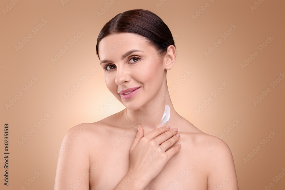 Beautiful woman with smear of body cream on her neck against light brown background Beautiful woman with smear of body cream on her neck against light brown background