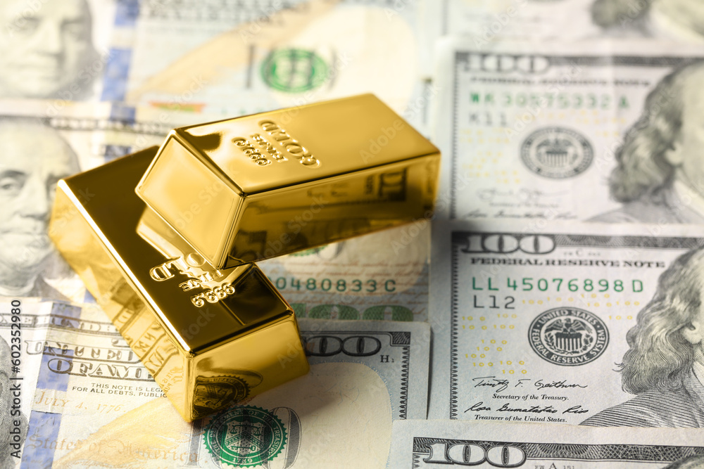 Shiny gold bars on dollar banknotes, closeup. Space for text Shiny gold bars on dollar banknotes, closeup. Space for text