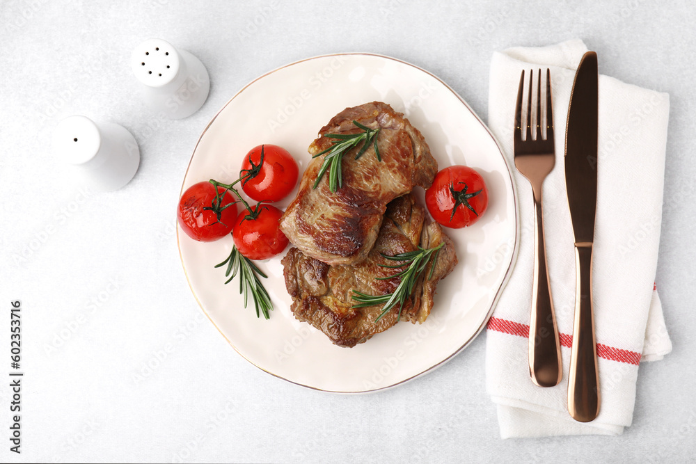 Delicious fried meat with rosemary and tomatoes served on light grey table, flat lay Delicious fried meat with rosemary and tomatoes served on light grey table, flat lay