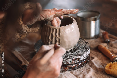 Female sculptor making clay mug in a home workshop,hands close-up.Small business,entrepreneurship,hobby, leisure concept.