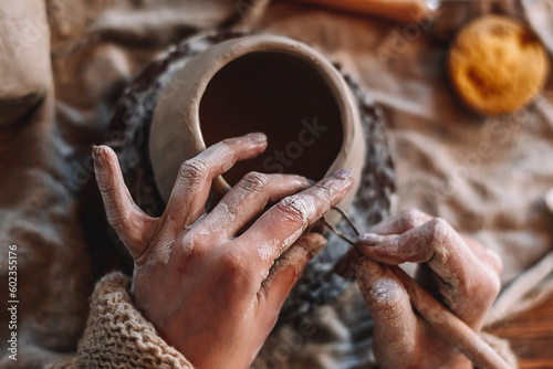 Female sculptor making clay mug in a home workshop,hands close-up.Small business,entrepreneurship,hobby, leisure concept.