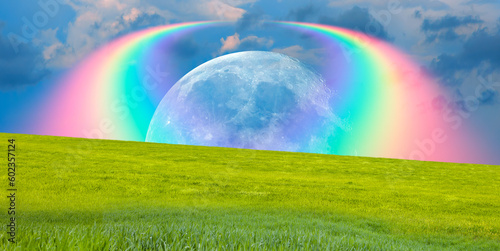 Beautiful landscape with green grass field  amazing rainbow over the moon in the background  Elements of this image furnished by NASA  