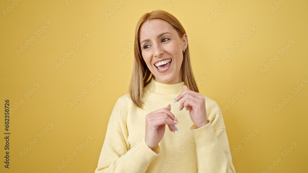 Young blonde woman smiling confident dancing over isolated yellow background Young blonde woman smiling confident dancing over isolated yellow background
