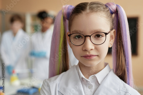 Canvastavla Closeup portrait of cute teen schoolgirl with pigtails wearing lab coat in scien