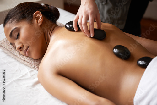 Girl, hands or back massage with rocks in spa to relax for zen, sleeping or wellness physical therapy. Woman, rest or calm client in salon to exfoliate for body healing treatment or hot stone therapy