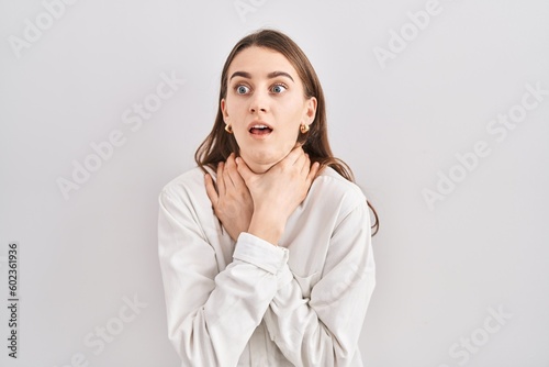 Young caucasian woman standing over isolated background shouting suffocate because painful strangle. health problem. asphyxiate and suicide concept.
