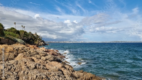 A rocky shore with Antibes in the background in French Riviera