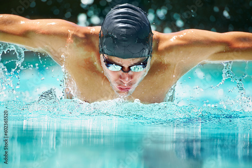 Health, sports and training with man in swimming pool for competition, workout and energy. Strong, water splash and cardio with male swimmer and practice for athlete, championship and race at gala photo