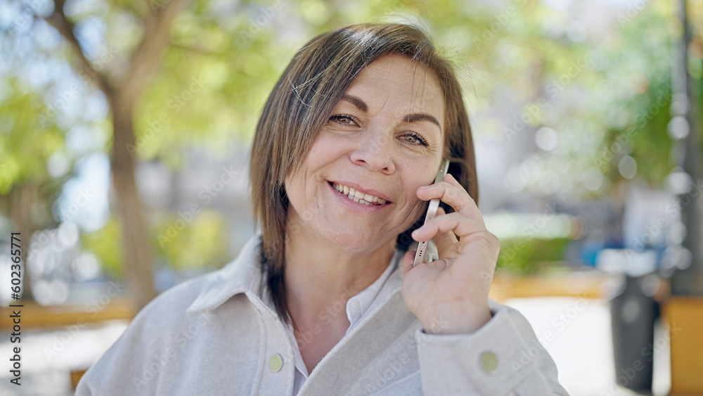 Middle age hispanic woman speaking on the phone at park Middle age hispanic woman speaking on the phone at park
