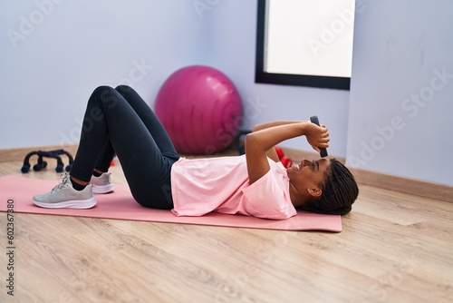 African american woman smiling confident training abs exercise at sport center