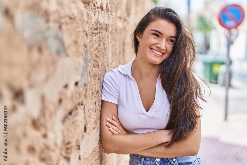 Young hispanic woman smiling confident standing with arms crossed gesture at street Young hispanic woman smiling confident standing with arms crossed gesture at street