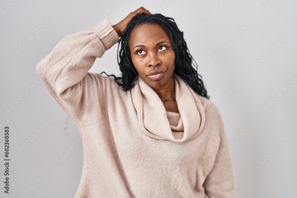 African woman standing over white background confuse and wondering about question. uncertain with doubt, thinking with hand on head. pensive concept. African woman standing over white background confuse and wondering about question. uncertain with doubt, thinking with hand on head. pensive concept.
