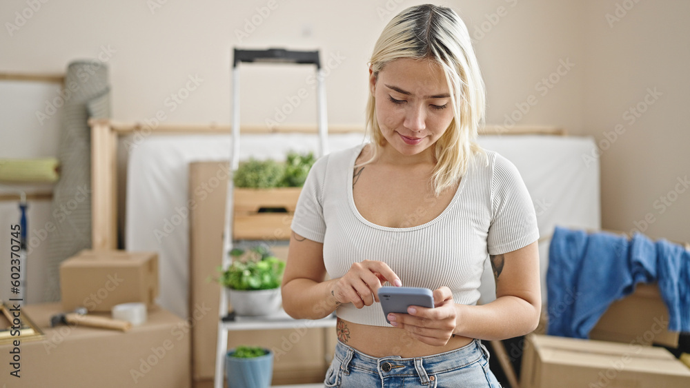 Young beautiful hispanic woman using smartphone at new home Young beautiful hispanic woman using smartphone at new home