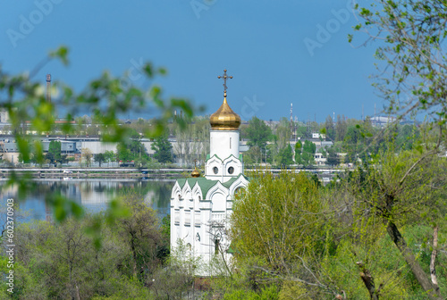 Church with golden domes and place religion of orthodox christian. Beautiful landscape with green park in middle of river. View of monastyrsky island with church of saint Nicholas in Dnipro Ukraine. photo