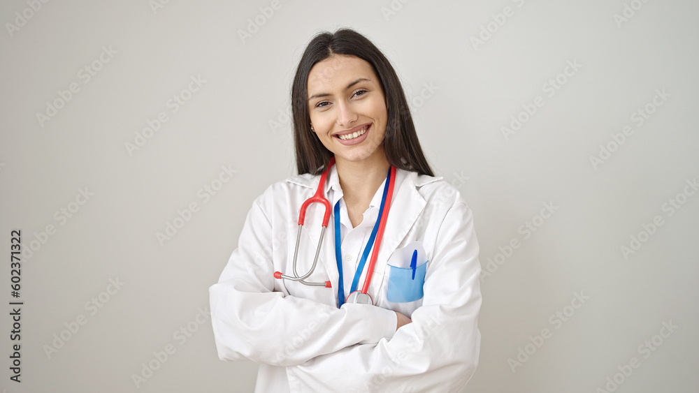 Young beautiful hispanic woman doctor smiling confident standing with arms crossed gesture over isolated white background Young beautiful hispanic woman doctor smiling confident standing with arms crossed gesture over isolated white background