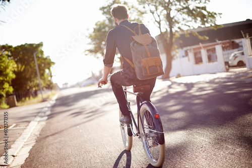 Bicycle, transport and back of man in street on lens flare for exercise, commute and cycling in morning. Travel, city and male cyclist on bike for eco friendly traveling, carbon footprint and journey © Miko/peopleimages.com
