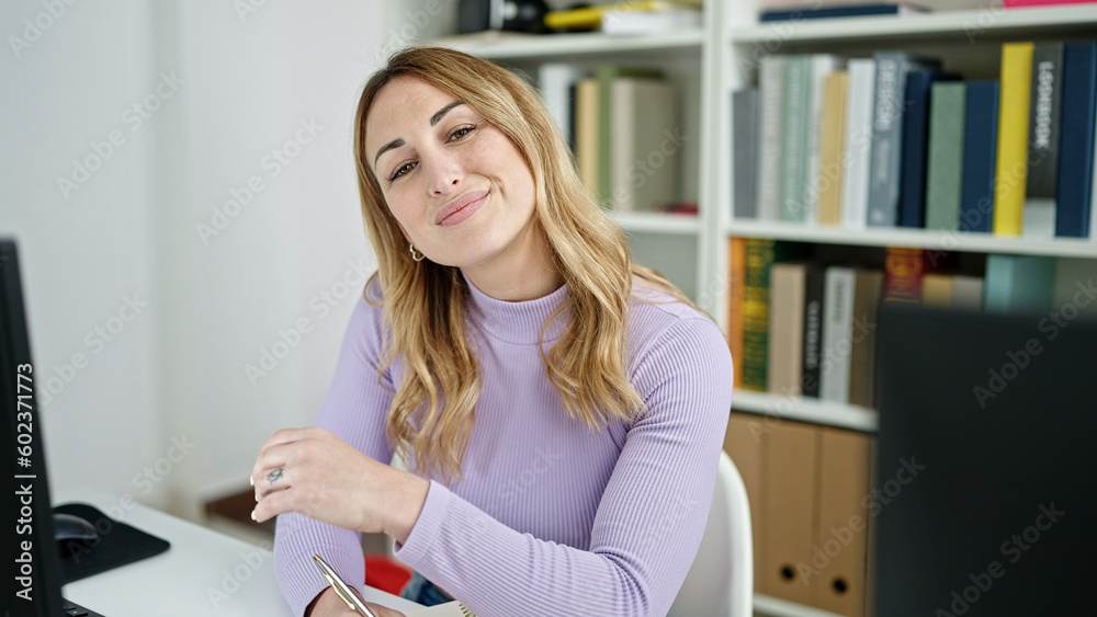 Young beautiful hispanic woman student using computer taking notes at library university Young beautiful hispanic woman student using computer taking notes at library university