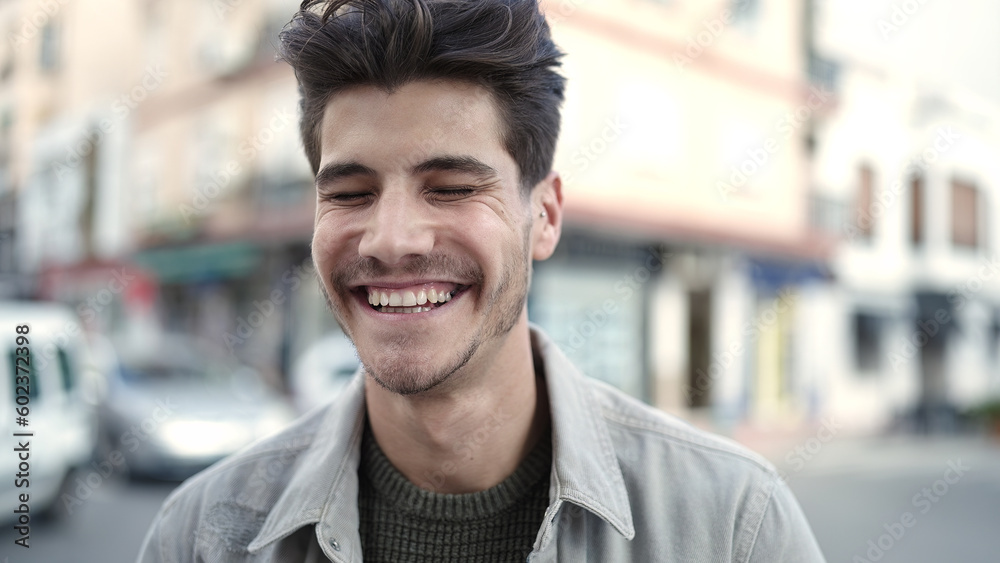 Fototapeta premium Young hispanic man smiling confident standing at street