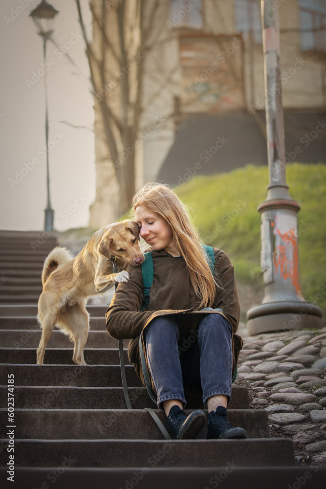 Beautiful blonde girl with dog in the city
