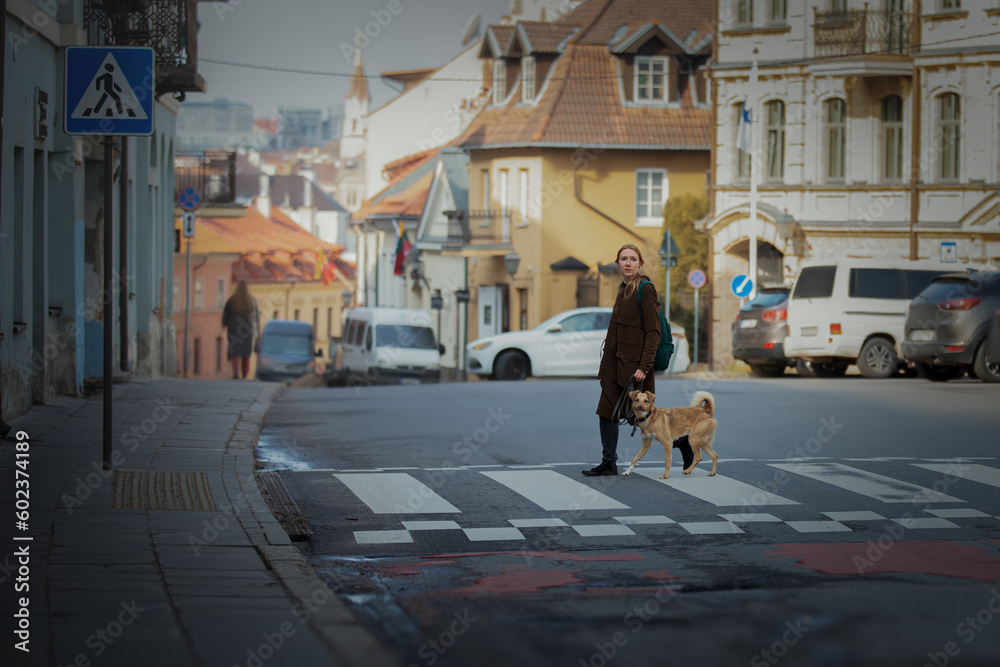 Beautiful blonde girl with dog in the city